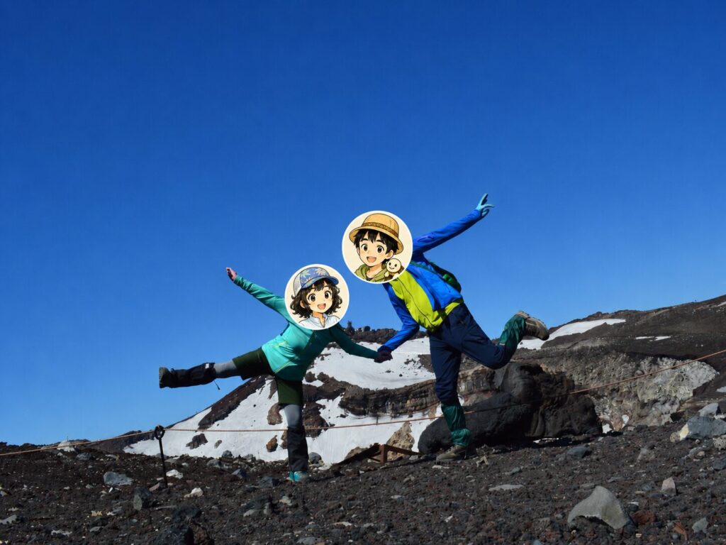 山頂付近で喜びのポーズで記念写真を撮っている男女の写真