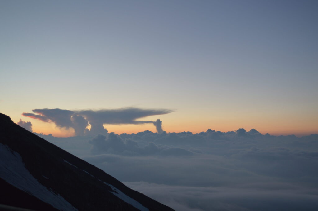 山小屋から見える夕焼けとダイナミックな雲の写真
