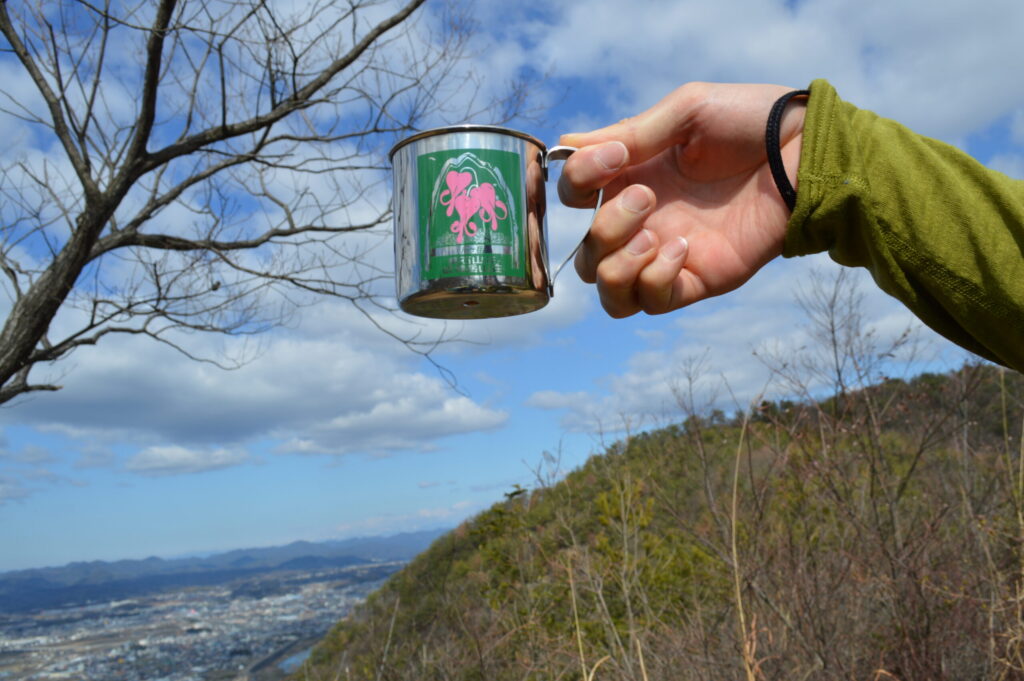 冬のハイキングで暖かいコーヒーを楽しむ人の写真